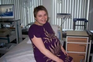 A woman demonstrating her plurality while sitting on a bed.